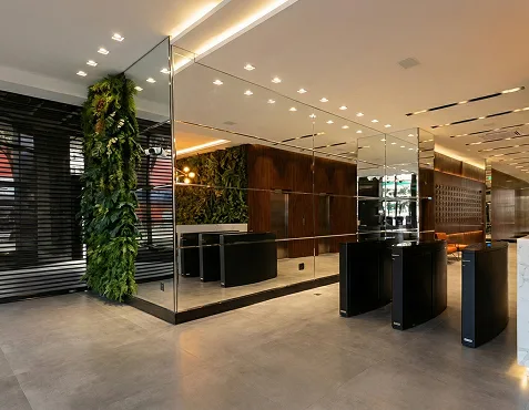 Recepção do edifício, com jardim vertical e acesso por catraca, escritório da Jani de Menezes